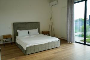 a bedroom with a white bed and a large window at Banya Villa Bucuresti sauna jacuzzi piscina spa in Gulia +41 photos