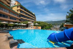 a pool at a hotel with a water slide at Inatori Akao Hotel in Higashiizu