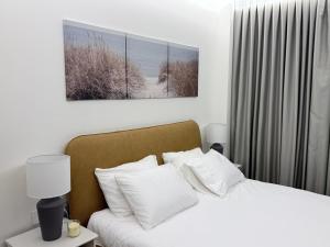 a bedroom with a bed with three paintings on the wall at סוויטת נווה in Pardes H̱anna