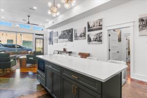 a kitchen with a white counter top and a living room at Downtown Mobile Pets Ok Walkable Secure Parking in Mobile +39 photos