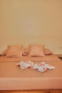 a large bed with two people in pink sheets at Verde Bungalows Siargao in General Luna