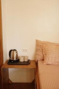 a bedroom with a bed and a tea kettle on a table at Verde Bungalows Siargao in General Luna +5 photos