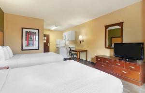 a hotel room with two beds and a flat screen tv at Extended Stay America Suites - Savannah - Midtown in Savannah