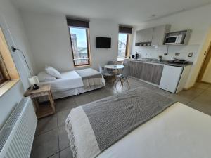 a hotel room with a bed and a kitchen at Apart Hotel Endurance in Punta Arenas