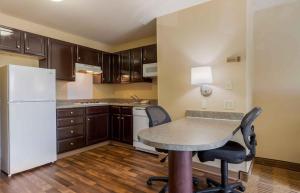 a kitchen with a table and chairs and a refrigerator at Extended Stay America Suites - Columbia - Northwest Harbison in Harbison