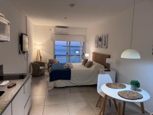 a bedroom with a bed and a table with chairs at Departamento sobre el Rio. in Corrientes