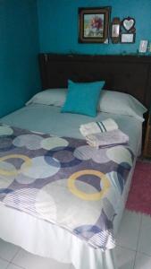 a bed with a blanket and pillows on it at Colorful Private Room Oasis in Montego Bay