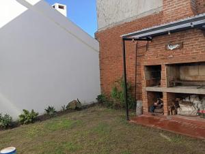 a brick building with an outdoor fireplace in a yard at Casa Rodas in Goya