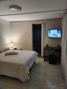 a bedroom with a bed and a flat screen tv at Hanca's Place in Parkwood