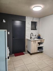 a kitchen with a black door and a sink at Hanca's Place in Parkwood