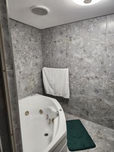 a bathroom with a white bath tub in a room at Hanca's Place in Parkwood