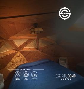 a bed in a room with a wooden ceiling at Espiritu Domo Lodge in Coinco