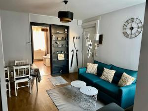 a living room with a blue couch and a table at Cocon entre centre ville autoroute in Reims