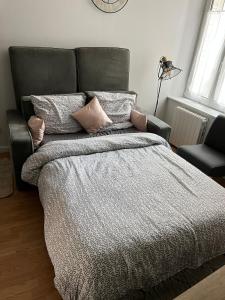 a bedroom with a large bed with pillows at Cocon entre centre ville autoroute in Reims +26 photos