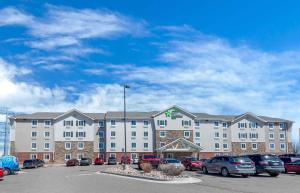 a large building with cars parked in a parking lot at Extended Stay America Suites - Denver - Airport in Aurora