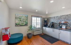 a kitchen with a blue chair and a counter at Extended Stay America Suites - Denver - Airport in Aurora