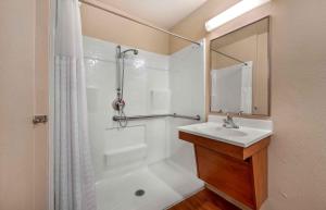 a white bathroom with a sink and a shower at Extended Stay America Suites - Denver - Airport in Aurora +24 photos