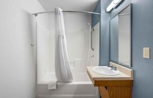 a bathroom with a shower curtain and a sink at Extended Stay America Suites - Portland - East in Portland +21 photos
