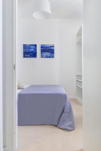a bed in a room with two pictures on the wall at Puolo Seaside Apartment in Massa Lubrense