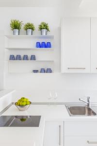 a white kitchen with a bowl of fruit on a counter at Puolo Seaside Apartment in Massa Lubrense