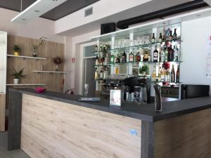 a bar with a black counter with bottles on it at La Vecchia Scuola in Villa Dalegno
