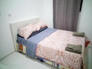 a small bed with a blue and white comforter and pillows at JF Condominio 