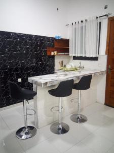 a kitchen with two bar stools and a counter at JF Condominio 