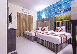 a hotel room with two beds and a painting on the wall at company Of Hotel in New Delhi