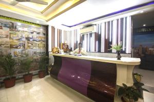 a woman sitting at a bar in a hotel lobby at company Of Hotel in New Delhi