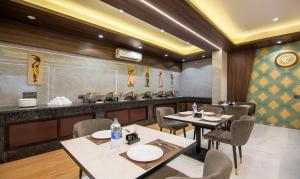 a restaurant with tables and chairs and a counter at company Of Hotel in New Delhi