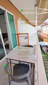 a table and a chair on a balcony at Baan Tipsukon in Ko Larn