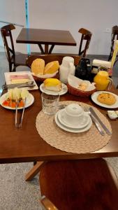 a wooden table with plates of food on it at Hotel Rota do Sul in Juquiá +12 photos