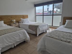 a hotel room with two beds and a large window at Apart Hotel Endurance in Punta Arenas