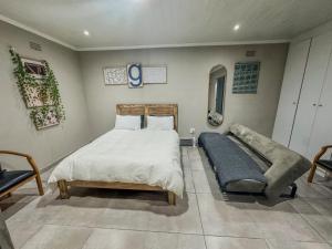 a bedroom with a bed and a couch in it at Blade Flatlet 2 in Silver Sands