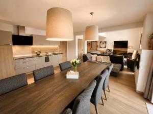 a living room and kitchen with a wooden table and chairs at SNOW LAKE Lipno in Lipno nad Vltavou