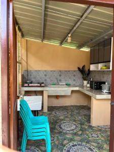 a kitchen with a table and a blue chair at SunriseStay in Panglao Island +30 photos