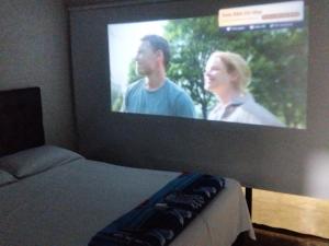 a television screen with a man and a woman on it at Las Margaritas Cabin in Chinchiná