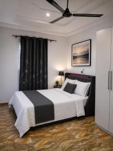 a bedroom with a bed and a ceiling fan at Fairview Executive Suites in Bawalishi