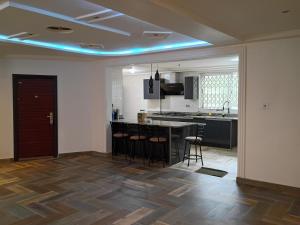a kitchen with a counter and stools in a room at Fairview Executive Suites in Bawalishi