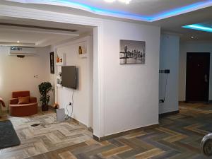 a room with a wall with a tv and a couch at Fairview Executive Suites in Bawalishi
