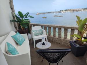 a balcony with chairs and a view of the water at Principe in Sanxenxo +46 photos