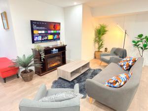a living room with couches and a flat screen tv at Fairway Retreat Chilliwack in Chilliwack