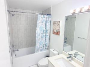 a white bathroom with a toilet and a sink at Fairway Retreat Chilliwack in Chilliwack +26 photos