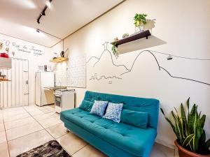 a living room with a blue couch and a kitchen at Vila Imper Host Itz - Apês com Wi-fi I A/C a 5 min. do Imperial Shopping in Imperatriz