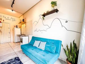 a living room with a blue couch and a kitchen at Vila Imper Host Itz - Apês com Wi-fi I A/C a 5 min. do Imperial Shopping in Imperatriz