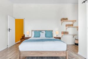 a bedroom with a large bed with blue pillows at The Tide & Seek House in Cape Town