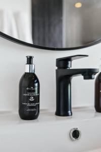 a bottle of soap sitting next to a bathroom sink at The Tide & Seek House in Cape Town