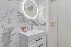 a white bathroom with a sink and a mirror at Quiet luxury at the Royal Route in Warsaw in Warsaw +27 photos