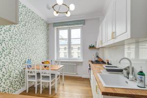 a kitchen with white cabinets and a table with chairs at Quiet luxury at the Royal Route in Warsaw in Warsaw