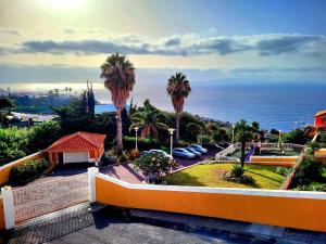 a view of the ocean from a balcony with palm trees at Esfera I Calm Stay With Parking & Workspace in Caniço